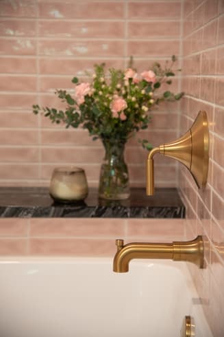 Powder bath detail with pink tile and brass faucet