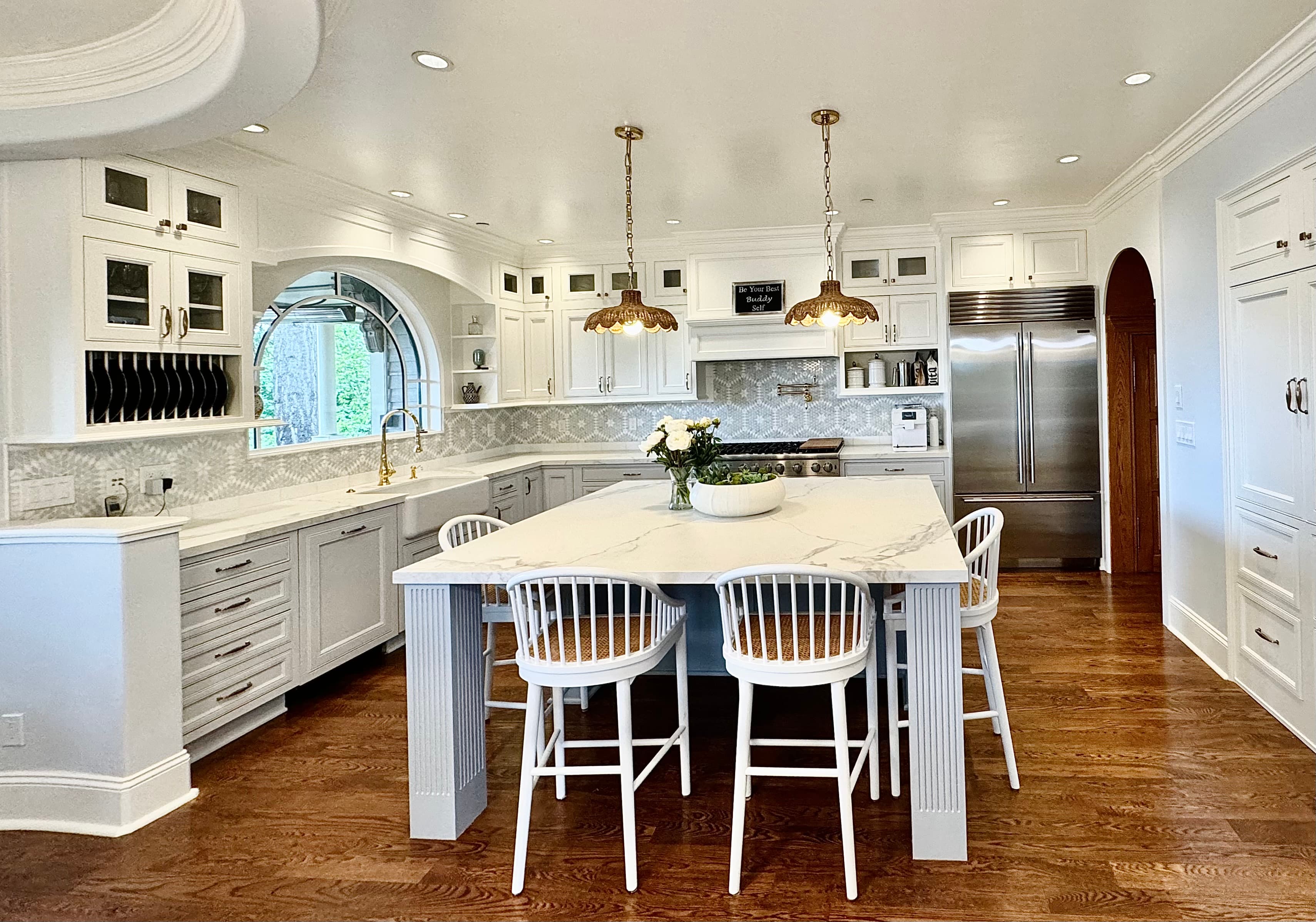 Classic white kitchen with island and arched window