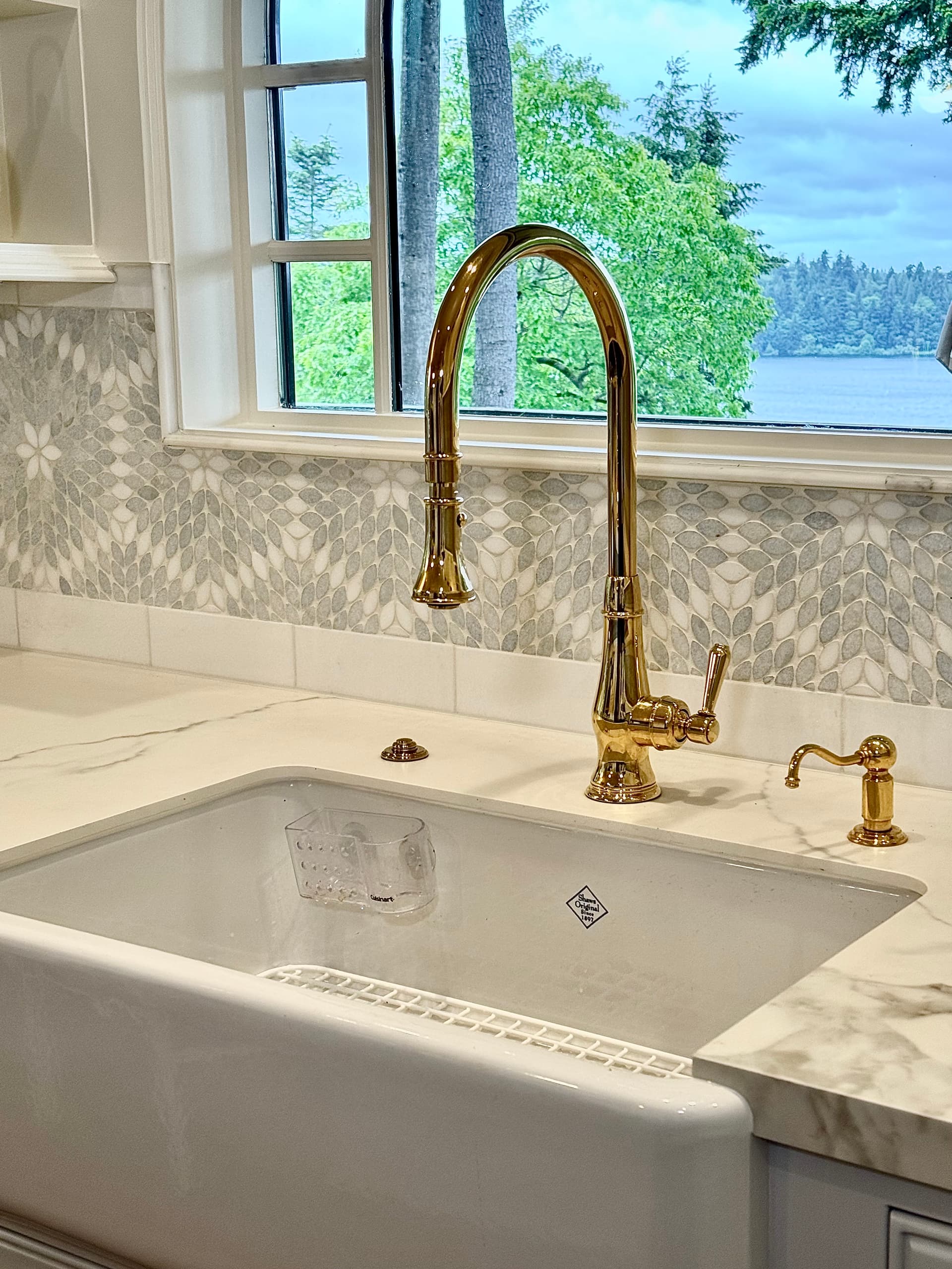 Farmhouse sink with gold faucet and mosaic backsplash
