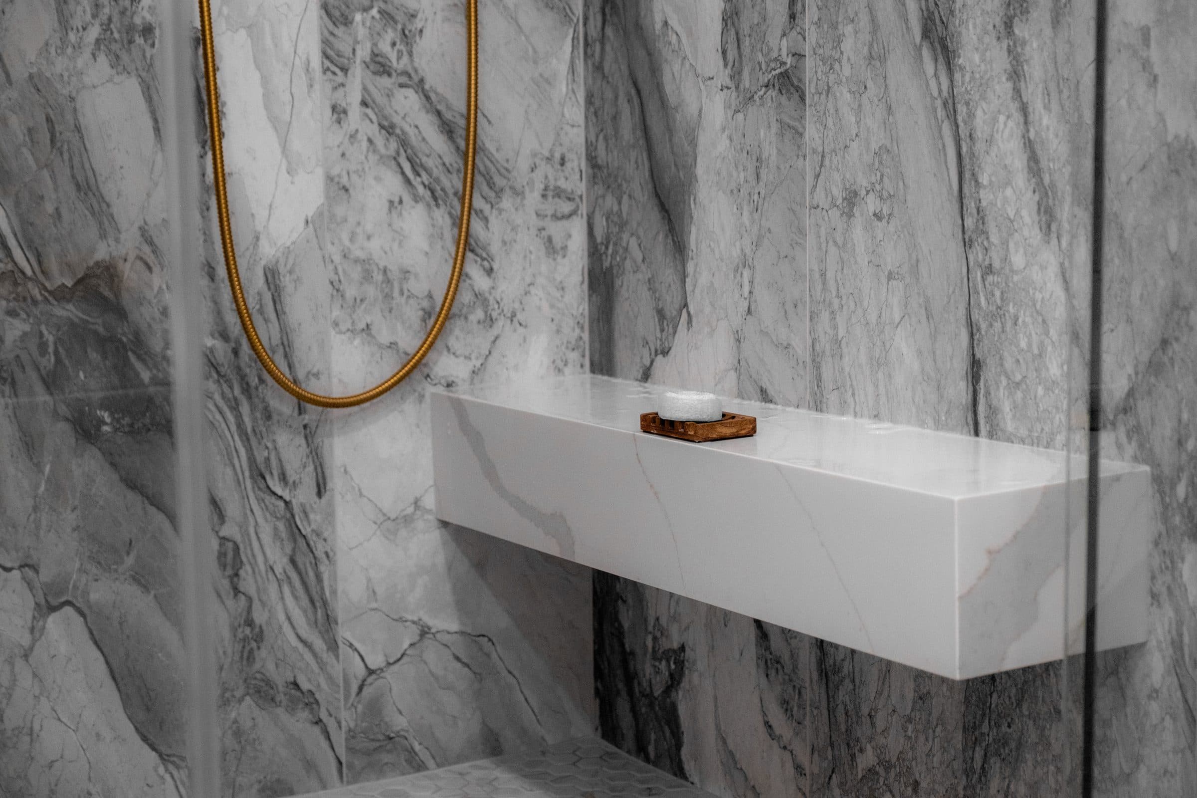 Floating marble shower bench with brass hand shower