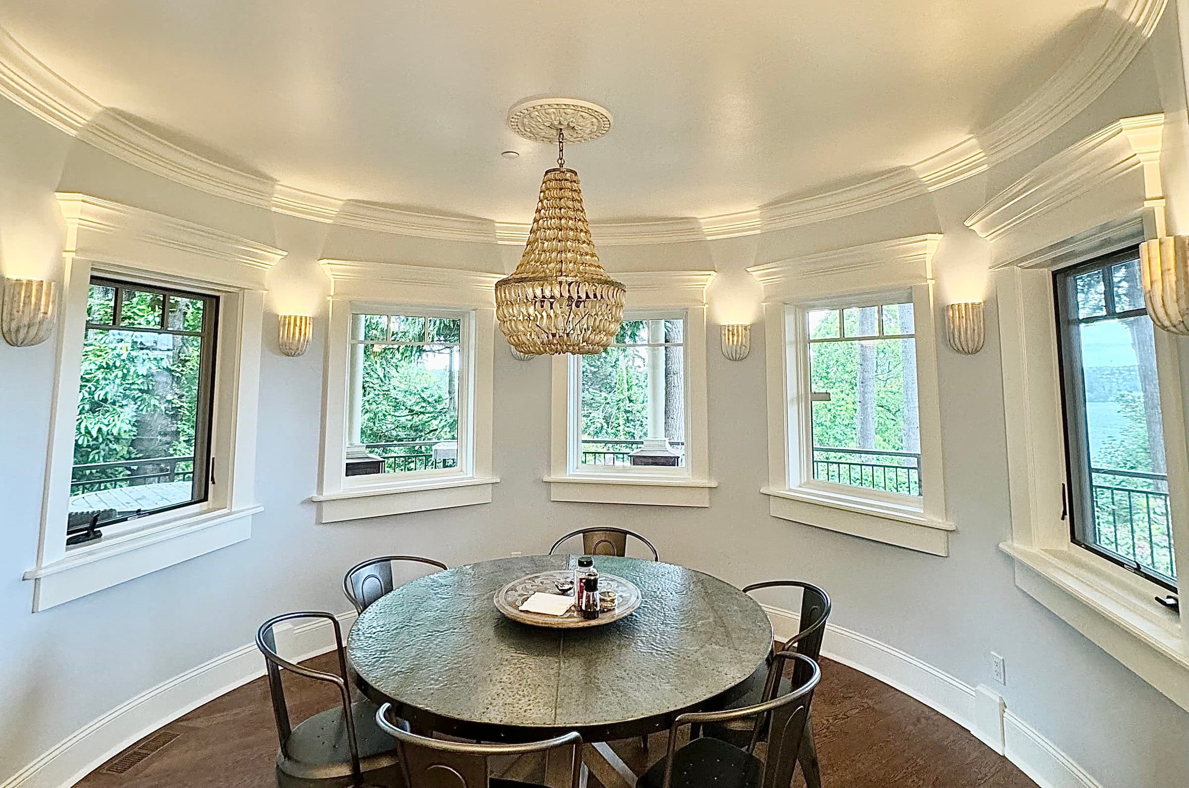 Round dining room with beaded chandelier and panoramic windows